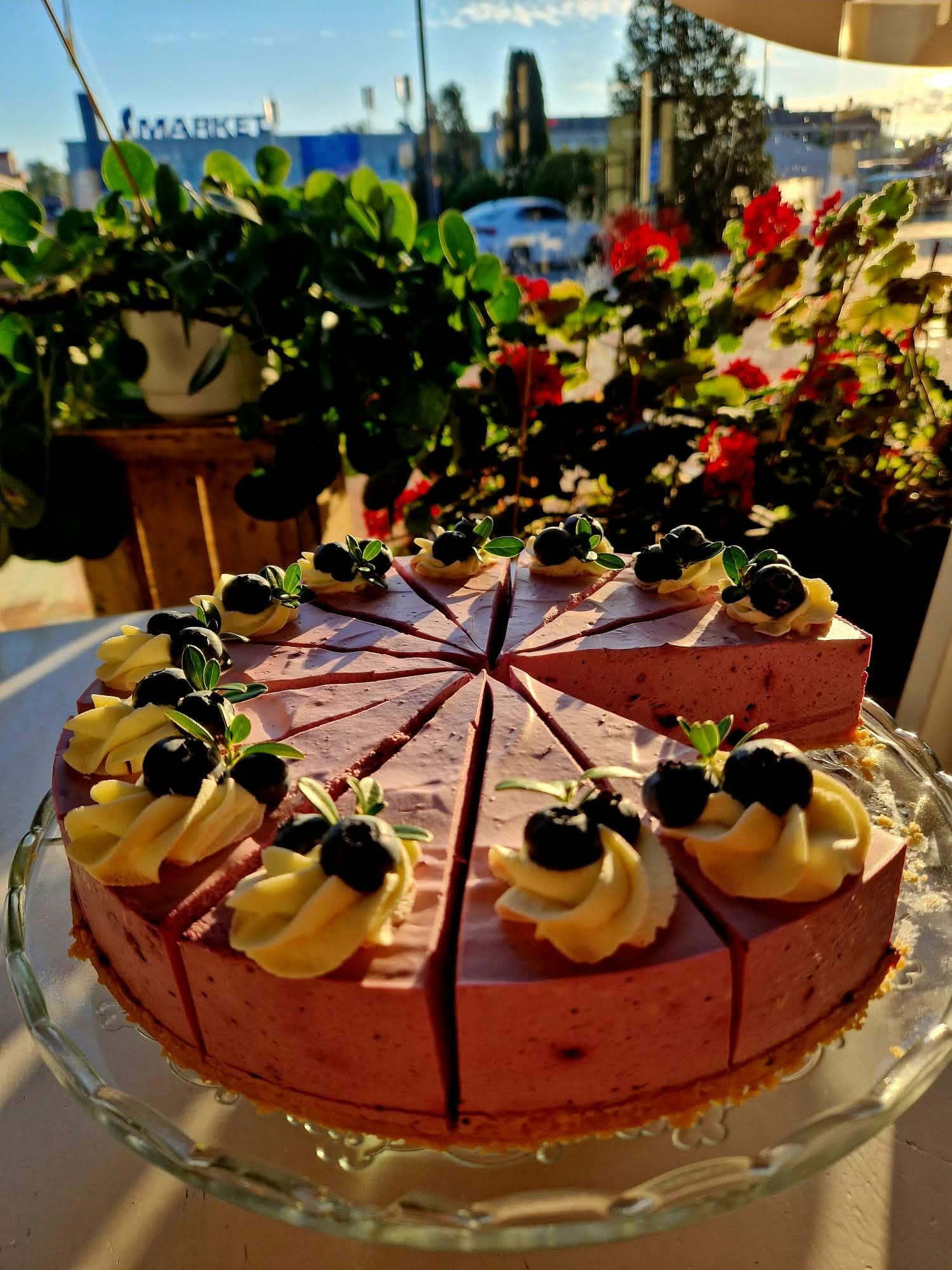 Marjoilla koristeltu juustokakku kahvilan ikkunan äärellä